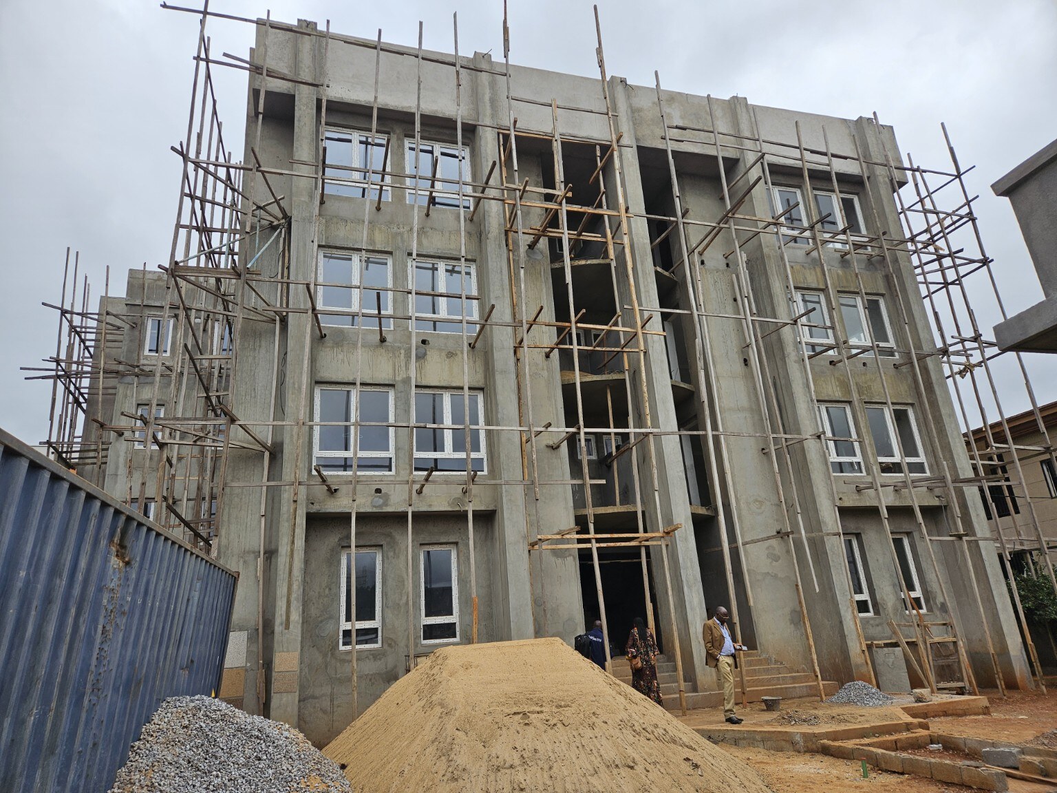 Wide construction view of the Golf Residences façade showing its vertical piers, recessed balconies, windows, and ongoing exterior work.